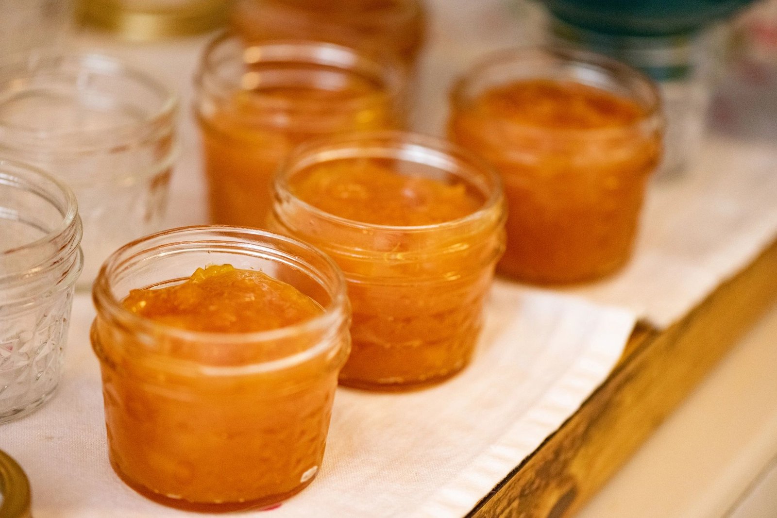 Jars of homemade jam cooling on a countertop