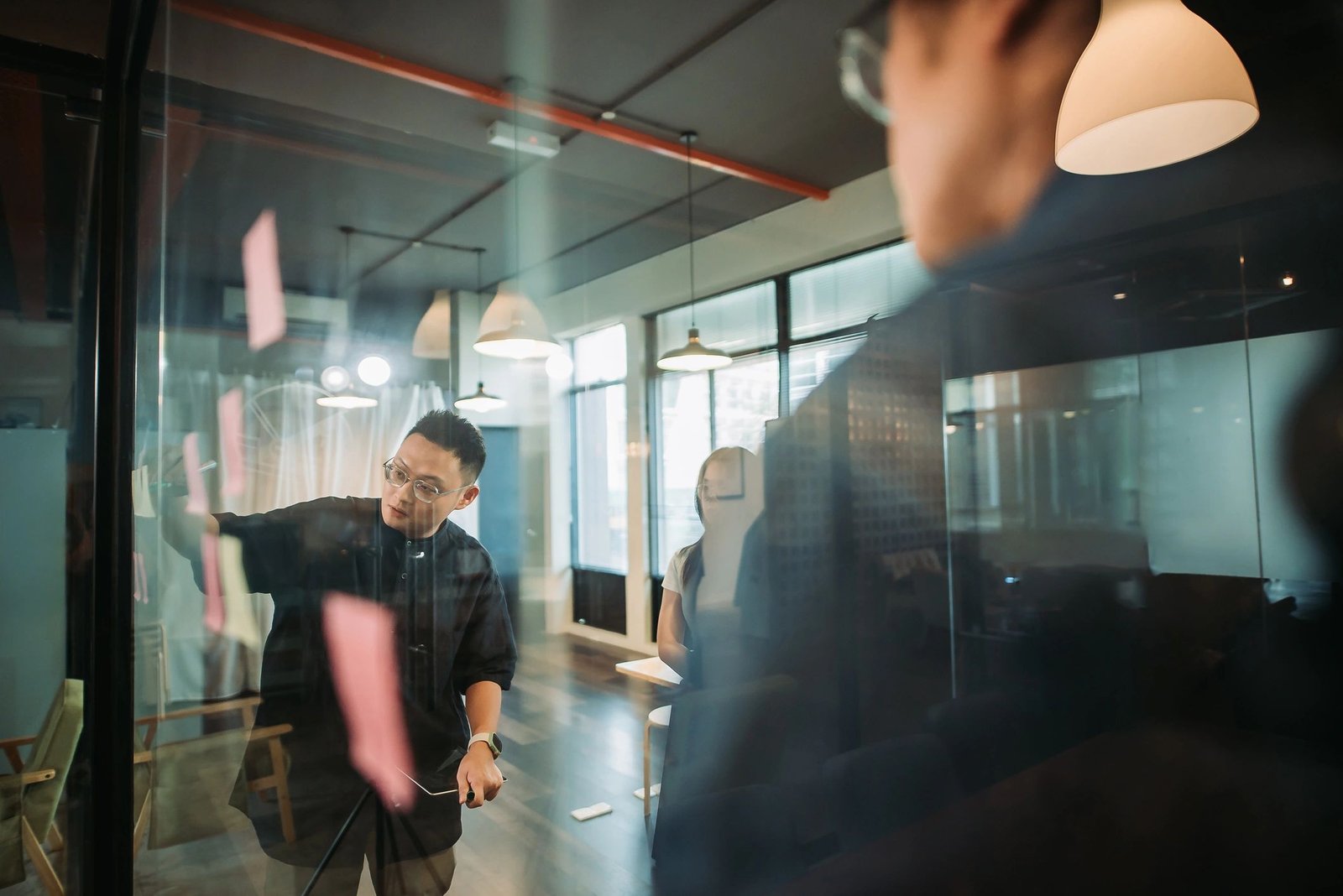 Team planning with sticky notes on a glass board—project planning and collaboration