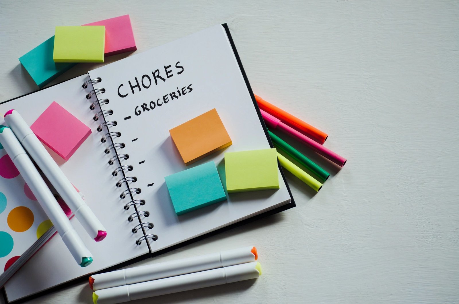 Notebook with colorful sticky notes on a white table
