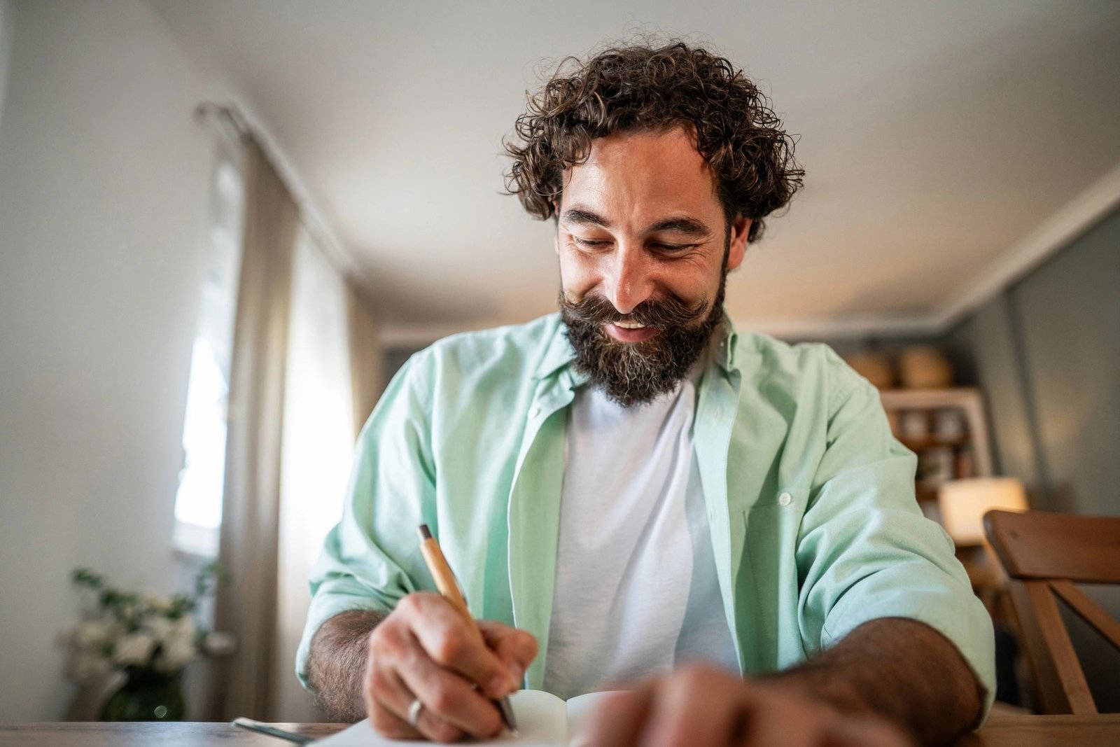 Man writing in a journal at home